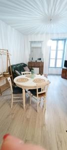 ein Wohnzimmer mit einem Tisch und einem Sofa in der Unterkunft Appartement cosy à 2 pas des rues piétonnes in Chalon-sur-Saône