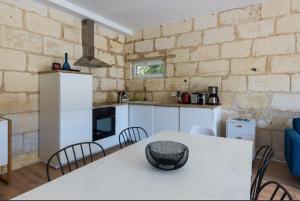 a kitchen with a white table with chairs and a counter at Chateau La Fontaine in Fronsac