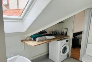 a bathroom with a white washing machine and a shelf at Lovely 1 room Apartment Aarhus C in Aarhus