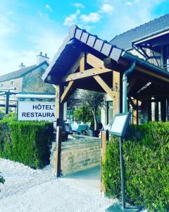 a sign for a hotel restaurant in front of a building at Logis Le Marronnier in Buffon