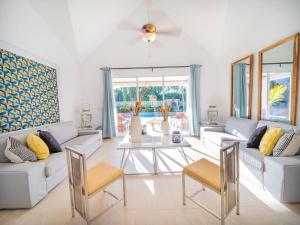 a living room with white furniture and a table at Sun Soul - Caribbean 9br Villa In Sosua in Sosúa