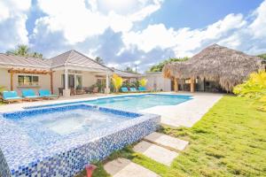 a villa with a swimming pool and a yard at Sun Soul - Caribbean 9br Villa In Sosua in Sosúa