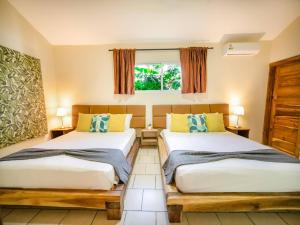 a bedroom with two beds and a window at Sun Soul - Caribbean 9br Villa In Sosua in Sosúa