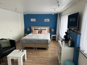 een slaapkamer met blauwe muren en een bed met roze kussens bij B&B Binisa in Westkapelle