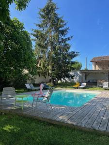 - une piscine avec deux chaises et un flamingo rose à côté dans l'établissement Chateau La Fontaine, à Fronsac