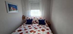 Un dormitorio con una cama con flores rojas. en Rooftop Panorama - AC, 4ppl, TV, en Budapest