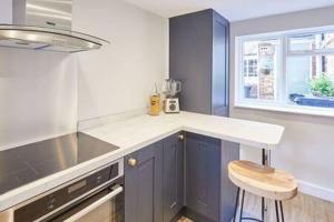 a kitchen with blue cabinets and a white counter top at Host & Stay - 2 College Square in Stokesley