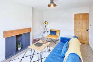 a living room with a blue couch and a fireplace at Host & Stay - 2 College Square in Stokesley