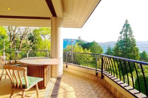 einen Balkon mit einem Tisch und Stühlen sowie Aussicht in der Unterkunft Open-air bath & Private hot-spring Villa in Hakone in Onsensō