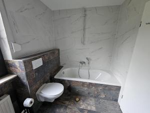 MürlenbachにあるFamiliehuis Dolveのバスルーム(白いバスタブ、トイレ付)