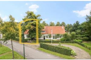 ein Haus mit einem gelben Bogen an der Seite einer Straße in der Unterkunft Sfeervol Voorhuis in Bladel