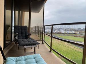 balcón con sillas y vistas a un campo en Appartement aan de yachthaven en Nieuwpoort