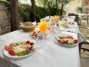 a table with plates of food and glasses of orange juice at Arial Lofts in Vlorë