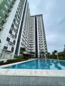 a large apartment building with a swimming pool in front of it at Centrio Tower condominium in Cagayan de Oro