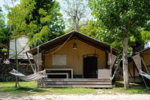 une maison avec deux hamacs devant elle dans l'établissement Glamping Florence, à Troghi