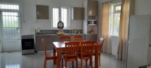 kuchnia z drewnianym stołem i krzesłami w pokoju w obiekcie Cozy Appartment w mieście Trianon
