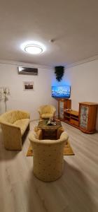 een woonkamer met 2 stoelen, een tafel en een tv bij Rooftop Panorama - AC, 4ppl, TV in Boedapest