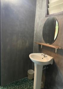 een badkamer met een wastafel en een spiegel bij Smile Buffalo Resort สไมล์ รีสอร์ท 