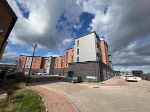 a building with a green car parked in a parking lot at Pass the Keys Cosy 2 Bedroom Apartment in Barry with Parking in Barry