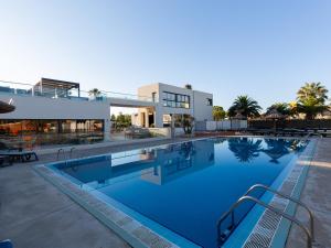 a large swimming pool in front of a building at Mobil Home XXL 4 chambres - Camping Les Tropiques in Torreilles