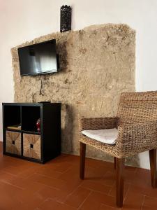 sala de estar con silla y TV en la pared en Apartamentos Jerez Siglo XIX, en Jerez de la Frontera