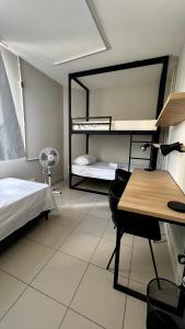 sypialnia z łóżkiem, biurkiem i biurkiem w obiekcie Belô Hostel w mieście Belo Horizonte