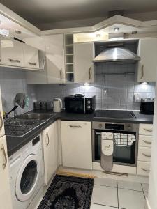 a kitchen with a stove and a washing machine at Stratford views in London