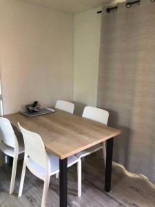 a dining room table with white chairs around it at Mobil home détente Biscarrosse in Biscarrosse