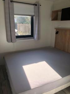 a small room with a window and a mattress at Mobil home détente Biscarrosse in Biscarrosse