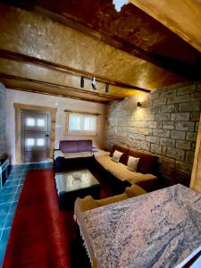 a living room with a couch and a stone wall at Skadar Lake Apartment Nikola I in Virpazar