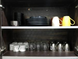 a shelf with plates and mason jars and cups at Homlee-Vintage Green 2BHK with Terrace & fort View in New Delhi