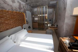 um quarto com uma cama branca e uma casa de banho em Hotel Faro Lariño em Lariño
