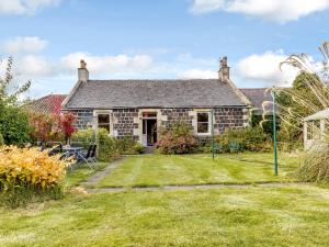 an old stone house with a lawn in front of it at 3 Bed in Edinburgh 79550 in Kirknewton
