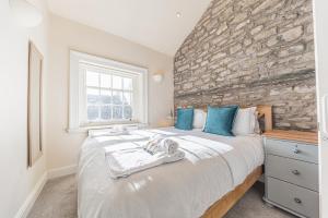 um quarto com uma cama grande e uma parede de pedra em Central Kendal Georgian Home with private courtyard & free parking em Kendal