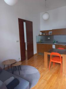 a living room with an orange chair and a kitchen at Apartmán Pistácia priame centrum BB in Banská Bystrica