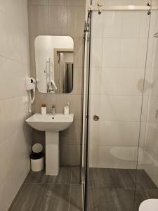 La salle de bains est pourvue d'un lavabo et d'une douche en verre. dans l'établissement Hotel Avenue 30, à Erevan