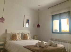 a bedroom with a white bed with towels on it at Estudio5 in Tudela