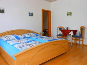 a bedroom with a wooden bed and a table and chairs at Pension im Oderbruch in Manschnow