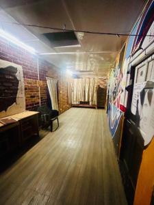 Cette chambre vide est dotée de parquet et d'un mur en briques. dans l'établissement Isabella Hostel, à Shillong