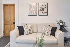 uma sala de estar com um sofá com almofadas em Host & Stay - High Street Cottage em Norton