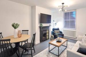 uma sala de estar com uma mesa e uma sala de estar com uma lareira em Host & Stay - High Street Cottage em Norton