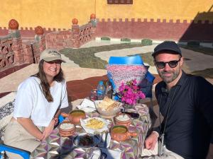 un homme et une femme assis à une table avec de la nourriture dans l'établissement Arafa Nubian Guest house, à Assouan