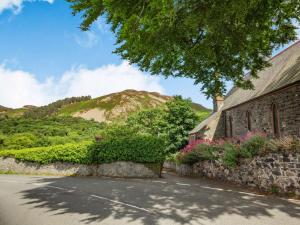 a building with a mountain in the background at 3 bed in Conwy 87866 in Penmaen-mawr