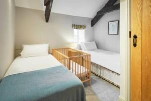 a small bedroom with two beds and a crib at Host & Stay - Himmell in Consett +12 photos