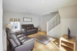 a living room with a leather couch and a television at Host & Stay - Mill in Consett