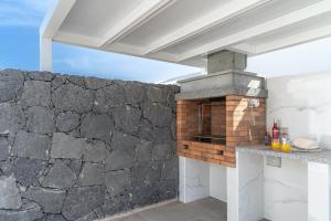 eine Außenküche mit einer Steinmauer in der Unterkunft VV Villa Secretos de Yaiza 3 by HH - private pool & BBQ in Yaiza
