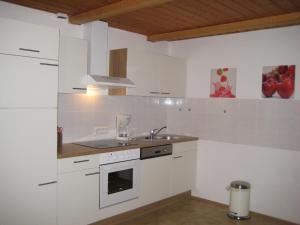 eine Küche mit weißen Schränken und einem Waschbecken in der Unterkunft Ferienwohnung Ampergarten in Grafrath