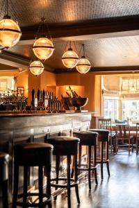 a bar with bar stools in a restaurant at Bedford Arms Hotel in Rickmansworth
