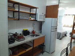 una cucina con lavandino e frigorifero di Condomínio da Fé - Studio Loft - 12º andar a Cachoeira Paulista