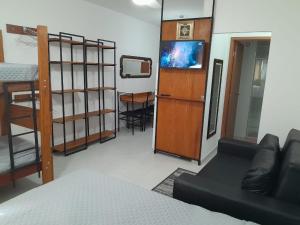 una camera con letto e TV e una camera con letto a castello di Condomínio da Fé - Studio Loft - 12º andar a Cachoeira Paulista